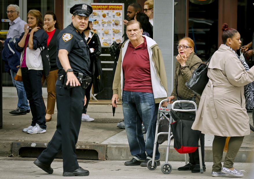 People react as NYPD officers investigate the scene of a stabbing, Wednesday May 24, 2017, in New York. Police say four teenagers have been stabbed on a street near New York City's Theater District during a fight among students outside a school. Authorities say they suffered non-life-threatening injuries. (AP Photo/Bebeto Matthews)