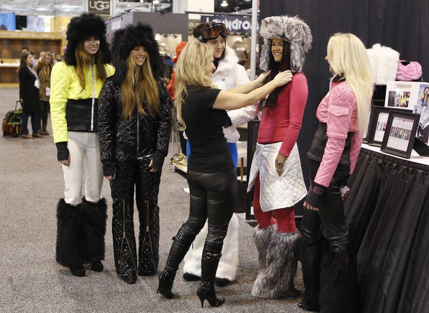 FILE - In this Jan. 31, 2013, file photo, Sonya Powell, owner and designer of Snow Sugar works with models wearing vinyl clothing at the Snow Sugar booth at the annual SIA Snow Show in Denver. Emerald Expositions, which produces the Outdoor Retailer trade show that's leaving Salt Lake City after two decades over political differences, announced Wednesday, May 24, 2017, it has acquired the SnowSports Industries America Snow Show that is held each winter in Denver. (AP Photo/Ed Andrieski, File)