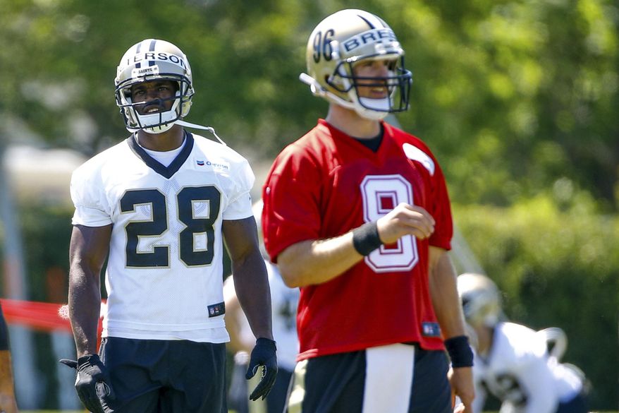 New Orleans Saints running back Adrian Peterson (28) stands behind quarterback Drew Brees (9) during NFL football practice in Metairie, La., Thursday, May 25, 2017. (AP Photo/Derick E. Hingle)