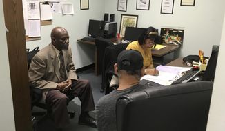 In this May 18, 2017, photo, Nathan Singletary, 67, a social worker for 40 years, listens as Employment Specialist Luz Rivera, 68, interviews program participant Luis Quinones, 66, front right, at the AARP Foundation in Harrisburg, Pa. Singletary is beyond the traditional retirement age, but he’s only just beginning a new career - helping other low-income, unemployed Americans over age 55 find jobs. Singletary got his job through the half-century-old Senior Community Service Employee Program, a training and placement program underwritten by taxpayers aimed at putting older Americans back into the workforce. (AP Photo/Laurie Kellman)