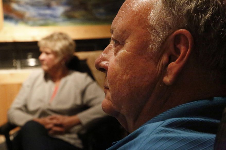 Kay and Jon St. John Sr. listen as their daughter, Sonja St. John, plays violin during a recording session on Saturday, May 13, 2017, at Surround In Sound Studio in Wauwatosa, Wis. Their son, Jon St. John II, died decade ago in the war in Iraq. She placed a photo of him on a nearby music stand for inspiration to help her get through the recording session. The song will be part of a second album released by Warrior Songs, a nonprofit arts organization for veterans. (AP Photo/Martha Irvine)