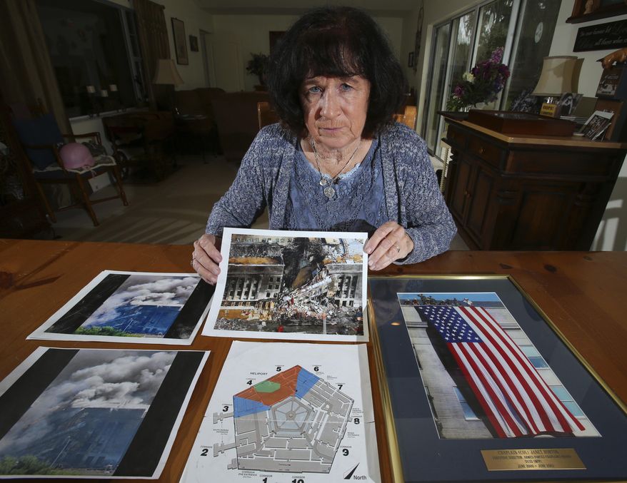 In this Thursday, March 23, 2017 photo, U.S. Army Col. Janet Horton, a retired military chaplain of 28 years, poses for a photo with pictures of the Pentagon from the Sept. 11 terrorist attack at her home in southeast Ocala, Fla. The terrorist plane struck the south side of the building where her office was, but she had been called away to get dental X-rays. Ironically, she was supposed to get them on August 11, her birthday, but the dental assistant had misplaced her file. (Bruce Ackerman/Star-Banner via AP)