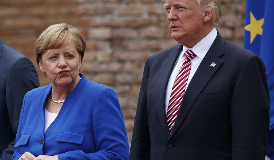 German Chancellor Angela Merkel and President Donald Trump pose for a family photo with G7 leaders at the Ancient Greek Theater of Taormina, Friday, May 26, 2017, in Taormina, Italy. (AP Photo/Evan Vucci)