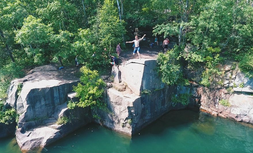 This June 10, 2016, photo provided by drone filmmaker Spencer Kuhlman shows a photograph made by Kuhlman using a drone above a popular cliff jumping and diving spot near St. Cloud, Minn. Kuhlman is a finalist in the first-ever Fargo, N.D., drone film festival, which will announce its winners next week. His piece called "Across The World" includes several action shots like the one shown in the photo. (Spencer Kuhlman via AP)