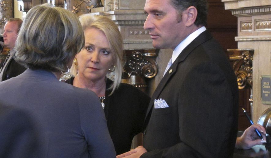 Kansas Senate President Susan Wagle, left, R-Wichita, confers with Sens. Julia Lynn, center, R-Olathe, and Ty Masterson, right, R-Andover, during a debate over a bill on banning concealed guns in hospitals, Tuesday, May 16, 2017, at the Statehouse in Topeka, Kan. The Senate has returned the bill to committee for more work with current state law allowing concealed guns in public hospitals starting in July. (AP Photo/John Hanna)