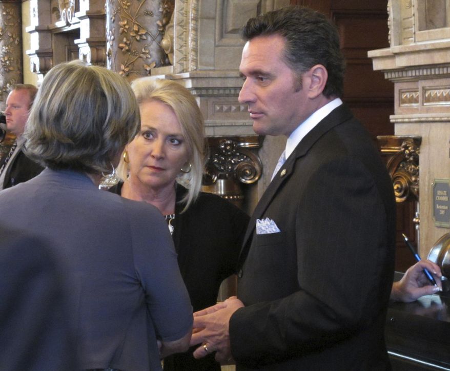 Kansas Senate President Susan Wagle, left, R-Wichita, confers with Sens. Julia Lynn, center, R-Olathe, and Ty Masterson, right, R-Andover, during a debate over a bill on banning concealed guns in hospitals, Tuesday, May 16, 2017, at the Statehouse in Topeka, Kan. The Senate has returned the bill to committee for more work with current state law allowing concealed guns in public hospitals starting in July. (AP Photo/John Hanna)