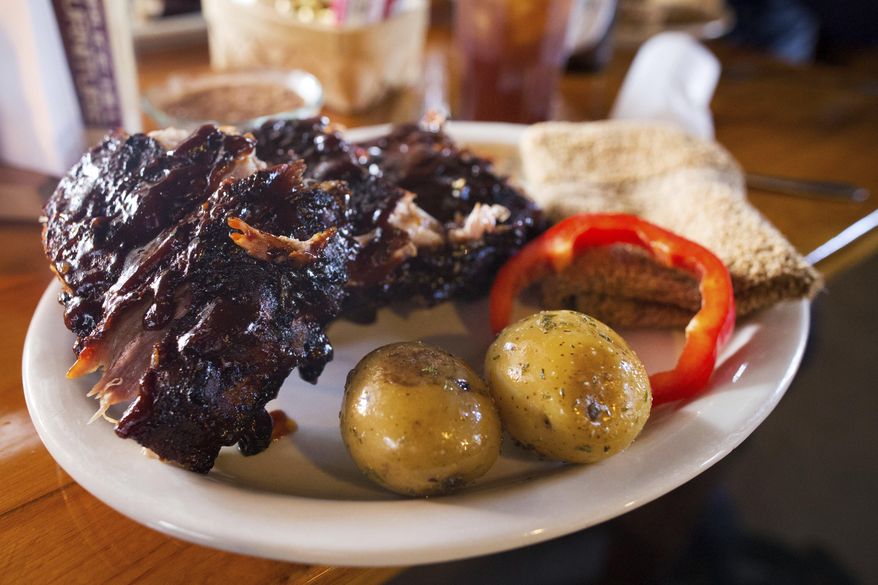 A plate of ribs is served to a customer at the High Plains Homestead Monday ,May 1, 2017, in Crawford, Neb. The High Plains Homestead is a bed-and-breakfast, a guest ranch, a restaurant and much more. It's an oasis in the middle of the northwest corner of the state where people can disconnect and enjoy nature. (Ryan Soderlin/Omaha World-Herald via AP)