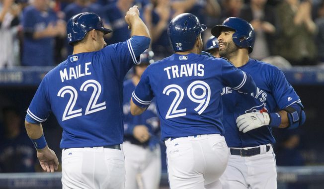 Toronto Blue Jays&#x27; Jose Bautista, right, celebrates with teammates Devon Travis (29) and catcher Luke Maile (22) after hitting a three-run home run against the Texas Rangers during the fifth inning of a baseball game in Toronto on Saturday, May 27, 2017. (Chris Young/The Canadian Press via AP)