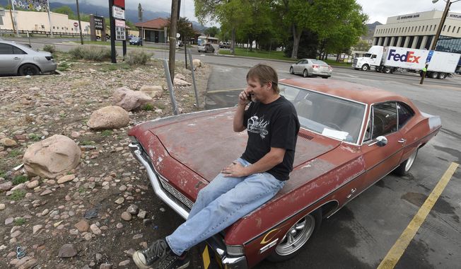 In this May 10, 2017, photo, Rick Ratzlaff talks on the phone while sitting on his vintage car in Canon City, Colo. Ratzlaff said he was surprised to find murder evidence from the cold case of a murdered teen inside the unit, which was rented by Lt. Robert Dodd with the Fremont County Sheriff&#x27;s Office. The contents were put up for auction after Dodd failed to make the payments on the unit. (Jerilee Bennett/The Gazette via AP)