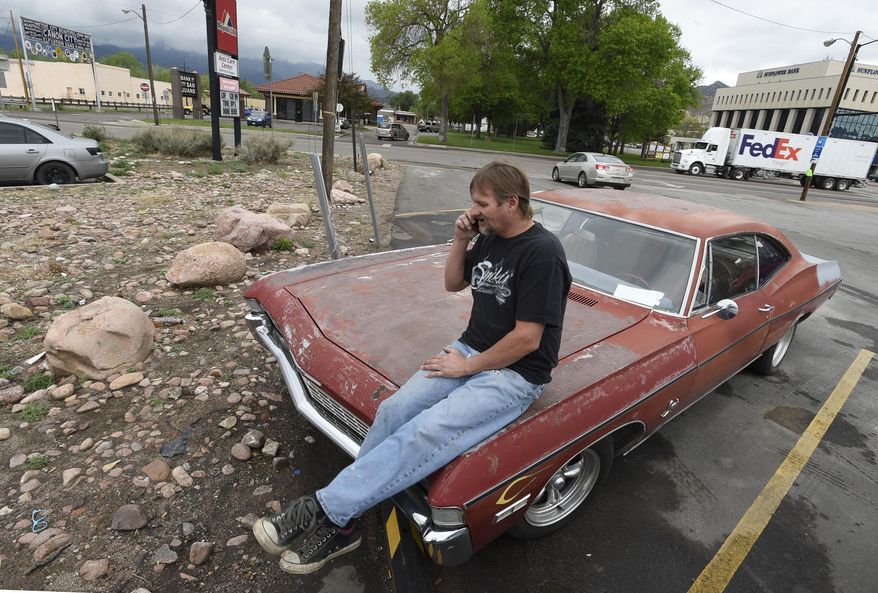 In this May 10, 2017, photo, Rick Ratzlaff talks on the phone while sitting on his vintage car in Canon City, Colo. Ratzlaff said he was surprised to find murder evidence from the cold case of a murdered teen inside the unit, which was rented by Lt. Robert Dodd with the Fremont County Sheriff's Office. The contents were put up for auction after Dodd failed to make the payments on the unit. (Jerilee Bennett/The Gazette via AP)