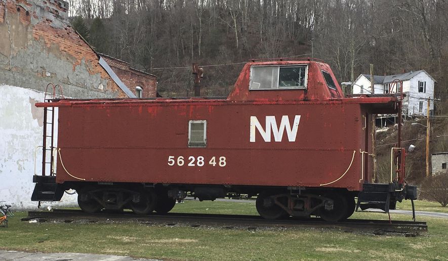 This Feb. 15, 2017 photo shows an old Norfolk and Western Railway caboose at the end of a rundown commercial block in Matoaka, W.V., where coal trains used to run several times a day and at night. In October 2015, Norfolk Southern discontinued regular freight service through the town. (AP Photo/Michael Virtanen)
