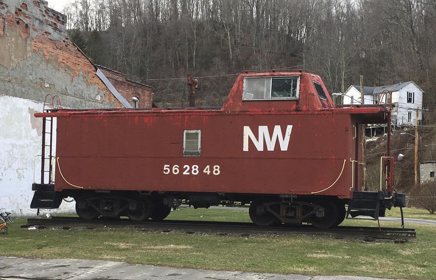 This Feb. 15, 2017 photo shows an old Norfolk and Western Railway caboose at the end of a rundown commercial block in Matoaka, W.V., where coal trains used to run several times a day and at night. In October 2015, Norfolk Southern discontinued regular freight service through the town. (AP Photo/Michael Virtanen)