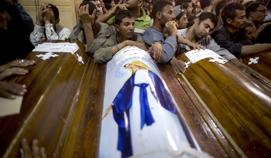 FILE - In this Friday, May 26, 2017 file photo, relatives of Coptic Christians who were killed during a bus attack, surround their coffins, during their funeral service, at Abu Garnous Cathedral in Minya, Egypt. The Libya connection in the Manchester concert bombing and Friday’s attack on Christians in Egypt has shone a light on the threat posed by militant Islamic groups that have taken advantage of lawlessness in the troubled North African nation to put down roots, recruit fighters and export jihadists to cause death and carnage elsewhere. ﻿(AP Photo/Amr Nabil)