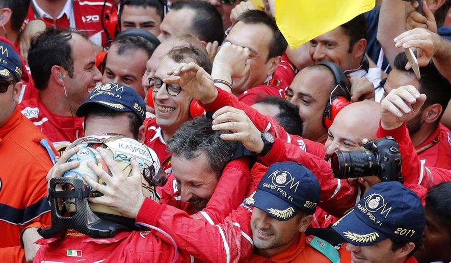 Ferrari driver Sebastian Vettel of Germany, left, celebrates after winning the Formula One Grand Prix at the Monaco racetrack in Monaco, Sunday, May 28, 2017. (AP Photo/Frank Augstein)