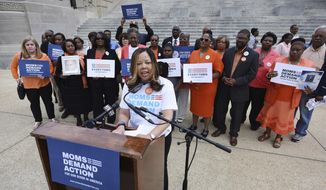 FILE- In this March 17, 2016, file photo, Lucy McBath, National Spokeswoman for Moms Demand Action for Gun Sense in America, is joined by faith leaders, gun violence survivors and others on the south steps of the Mississippi State Capitol in Jackson, Miss. McBath is afraid many more people will die if Florida Gov. Rick Scott signs a bill making it harder to prosecute when people claim they commit violence in self-defense. She already lost her son, an unarmed black teenager, when a white man angry over loud music and claiming self-defense fired at an SUV filled with teenagers. The measure before Scott would effectively require a trial-before-a-trial whenever someone invokes self-defense, making prosecutors prove the suspect doesn’t deserve immunity. (Joe Ellis/The Clarion-Ledger via AP, File)