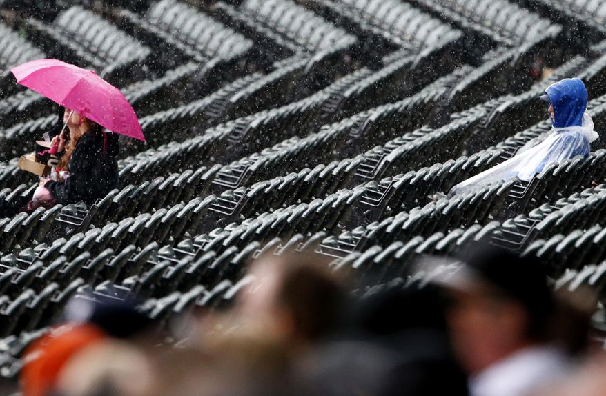 Baseball fans wait out a rain delay in the fourth inning in a baseball game between the Detroit Tigers and the Chicago White Sox, Sunday, May 28, 2017, in Chicago. (AP Photo/Nam Y. Huh)