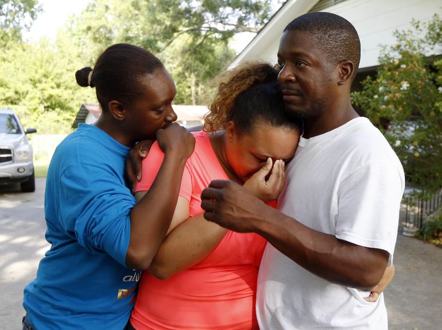 Christianna May-Kelly, center, is supported by family members as she cries after answering reporters questions outside her parents' home in Brookhaven, Miss., Sunday, May 28, 2017. May-Kelly said her mother was among the people gunned down during a shooting in rural Mississippi Saturday night. (AP Photo/Rogelio V. Solis)