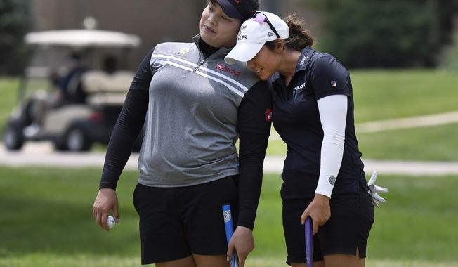 Ariya Jutanugarn of Thailand, left, and Marina Alex playfully lean on each other as they wait to putt on the 17th green during the final round of the LPGA Volvik Championship golf tournament at the Travis Pointe Country Club, Sunday, May 28, 2017 in Ann Arbor, Mich. (AP Photo/Jose Juarez)