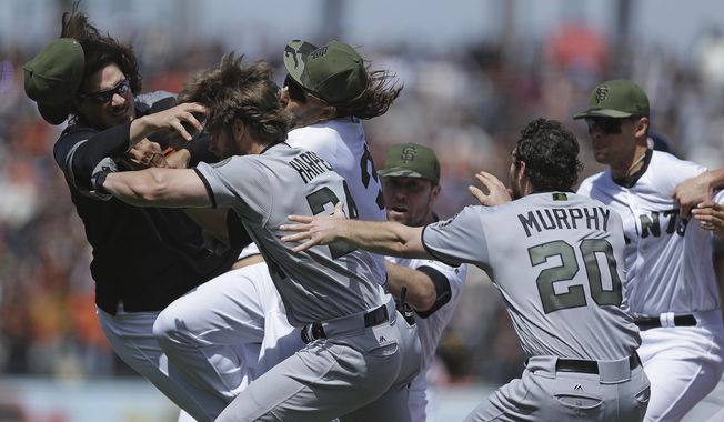 Washington Nationals&#x27; Daniel Murphy (20) tries to restrain teammate Bryce Harper (34) after Harper charged  San Francisco Giants&#x27; Hunter Strickland after being hit with a pitch in the eighth inning of a baseball game Monday, May 29, 2017, in San Francisco. (AP Photo/Ben Margot)