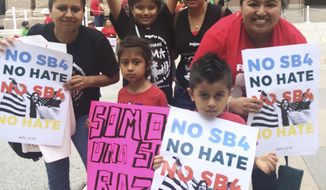 Rosario, right, and Marichuy, second from right in the back, demonstrate with family against a new Texas immigration law on Monday, May 29, 2017, in Austin, Texas. Opponents call Texas&#39; anti-sanctuary cities law a &amp;quot;show your papers&amp;quot; law since it empowers police to inquire about peoples&#39; immigration status during routine interactions such as traffic stops. (AP Photo/Meredith Hoffman)