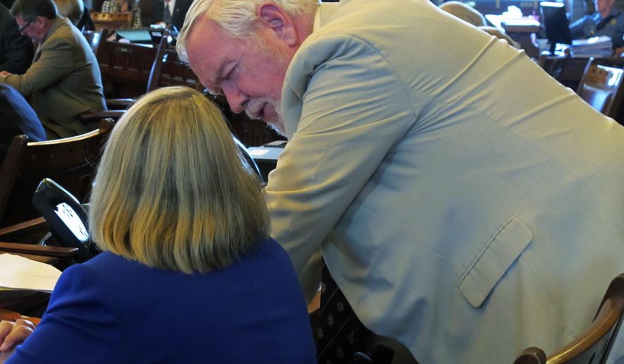 Kansas state Sen. Steve Fitzgerald, right, R-Leavenworth, confers with Sen. Molly Baumgardner, R-Louisburg, during a debate on a new disclosure requirement for abortion providers, Tuesday, May 30, 2017, at the Statehouse in Topeka, Kan. Lawmakers have passed the measure, which includes a requirement that patients receive information about doctors performing abortions printed on white paper in black, 12-point Times New Roman type. (AP Photo/John Hanna)