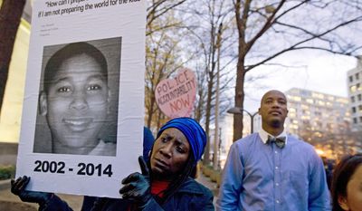 FILE – In this Dec. 1, 2014, file photo, Tomiko Shine, left, holds a sign with a photo of Tamir Rice, a boy fatally shot by a Cleveland police officer, while protesting a grand jury&#39;s decision in Ferguson, Mo., not to indict police officer Darren Wilson in the shooting death of Michael Brown, during a demonstration in Washington. Cleveland Police Chief Calvin Williams announced Tuesday, May 30, 2017, that Timothy Loehmann, the police officer who shot and killed the 12-year-old boy, has been fired for inaccuracies on his job application, while the officer who drove the patrol car the day of the Nov. 22, 2014, shooting, Frank Garmback, has been suspended for 10 days for violating a tactical rule for his driving that day. (AP Photo/Jose Luis Magana, File)