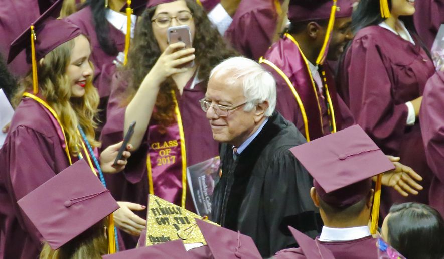 Vermont Sen. Bernie Sanders walks between graduates as he arrives for the Brooklyn College commencement ceremony, Tuesday, May 30, 2017, in New York. The former Democratic presidential candidate, who hails from Brooklyn and attended the school for a year, urged graduates to stand together and not let demagogues divide the country. (AP Photo/Bebeto Matthews)