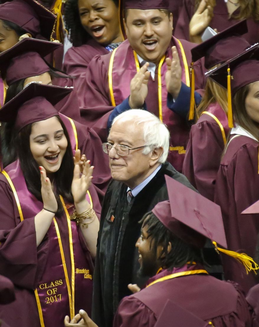 Vermont Sen. Bernie Sanders walks between graduates as he arrives for the Brooklyn College commencement ceremony, Tuesday, May 30, 2017, in New York. The former Democratic presidential candidate, who hails from Brooklyn and attended the school for a year, urged graduates to stand together and not let demagogues divide the country. (AP Photo/Bebeto Matthews)