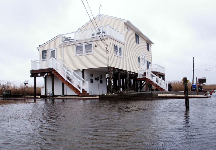 This March 14, 2017, photo shows Jim and Maryann O'Neill's home in a back bay neighborhood of Manahawkin N.J., surrounded by water after a moderate storm. Back bay flooding is a type of recurring nuisance flooding that affects millions of Americans and which experts agree has not been as widely addressed as oceanfront flooding, in part because potential solutions are much more difficult. (AP Photo/Wayne Parry)