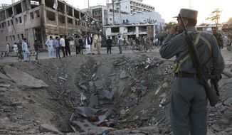 Security forces stand next to a crater created by massive explosion in front of the German Embassy in Kabul, Afghanistan, Wednesday, May 31, 2017. The suicide truck bomb hit a highly secure diplomatic area of Kabul killing scores of people and wounding hundreds more. (AP Photo/Rahmat Gul)