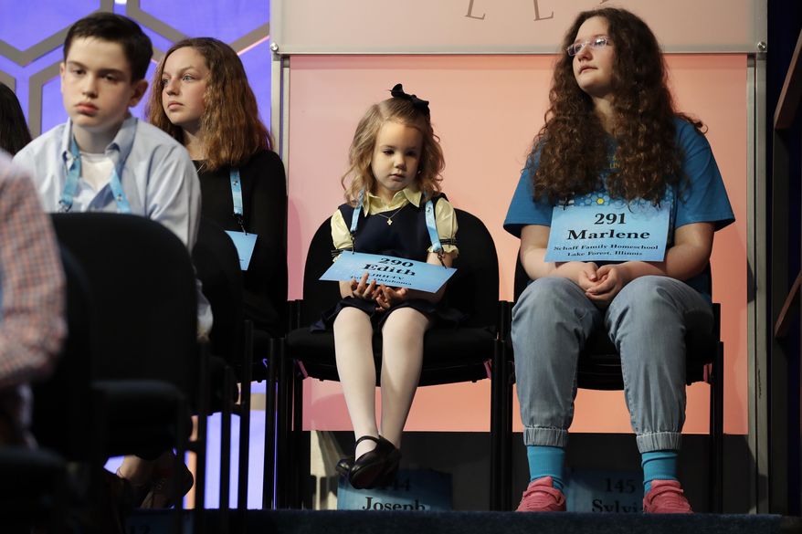 Edith Fuller, 6, of Tulsa, Okla., center, the youngest speller ever in the National Bee, sits next to Marlene Schaff, 14, of Lake Forest, Ill., right, as they wait to compete in the 90th Scripps National Spelling Bee in Oxon Hill, Md., Wednesday, May 31, 2017. (AP Photo/Jacquelyn Martin)