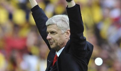FILE - In this Saturday, May 30, 2015 file photo, Arsenal manager Arsene Wenger salutes the fans after his team won the FA Cup in the English FA Cup Final soccer match between Aston Villa and Arsenal at Wembley stadium, London. Wenger will stay on as Arsenal manager, earning a new two-year contract on Wednesday, May 31, 2017 despite missing out on Champions League qualification. ((AP Photo/Rui Vieira, File)