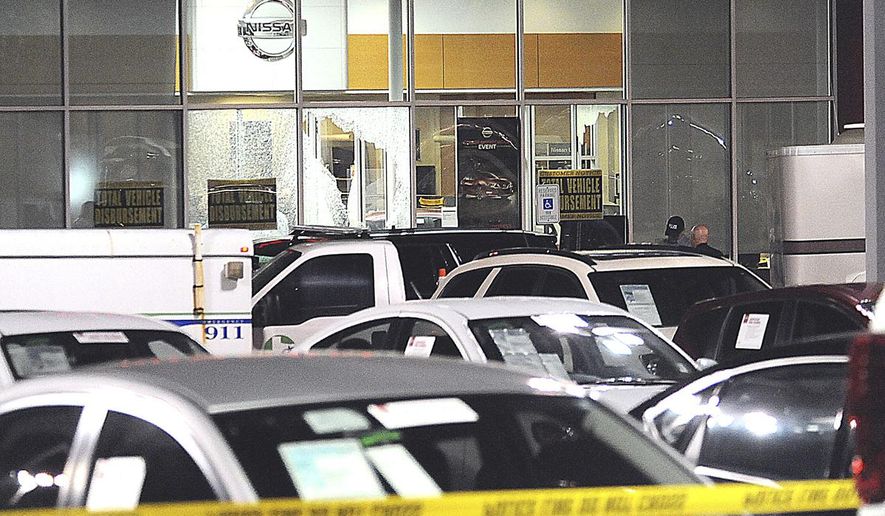 In this Tuesday, May 30, 2017 photo, police gather at the scene of a deadly shooting in Greenville, Texas. Authorities said Wednesday two bounty hunters and the fugitive from Minnesota they were tracking shot each other dead in a hail of bullets that sent customers and employees fleeing for cover at the car dealership. (David Claybourn/The Herald-Banner via AP)