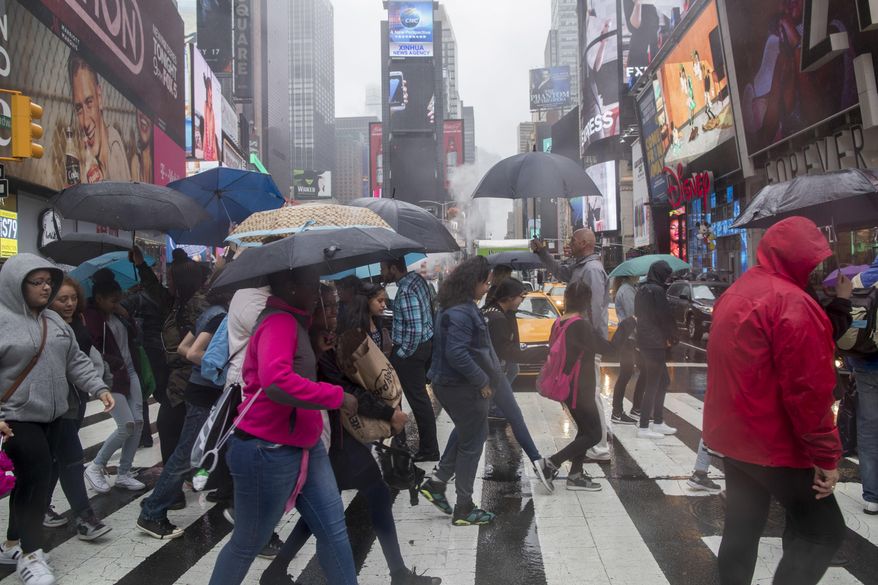 In this Thursday, May 25, 2017, photo, pedestrians make their way across 45th Street in New York's Times Square. The attack that killed an 18-year-old woman and injured 20 other people in Times Square is spurring calls to ban cars from the famed "crossroads of the world." Eight years after Broadway became a pedestrian-only zone at Times Square, some city officials and others say the vehicle restrictions should be expanded to include Seventh Avenue. (AP Photo/Mary Altaffer)