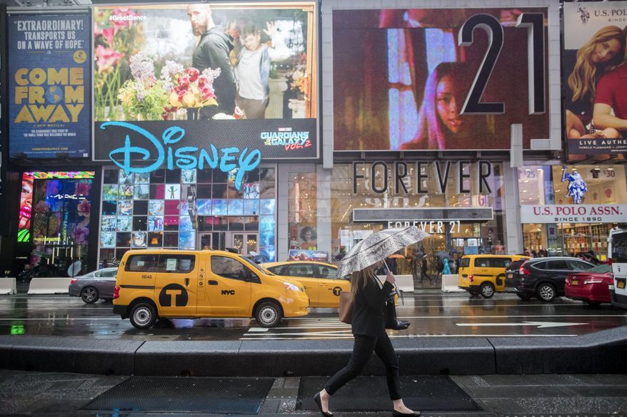 In this Thursday, May 25, 2017, photo, a pedestrian walks on the pedestrian mall in New York's Times Square as traffic makes it's way down Seventh Avenue. The attack that killed an 18-year-old woman and injured 20 other people in Times Square is spurring calls to ban cars from the famed "crossroads of the world." Eight years after Broadway became a pedestrian-only zone at Times Square, some city officials and others say the vehicle restrictions should be expanded to include Seventh Avenue. (AP Photo/Mary Altaffer)