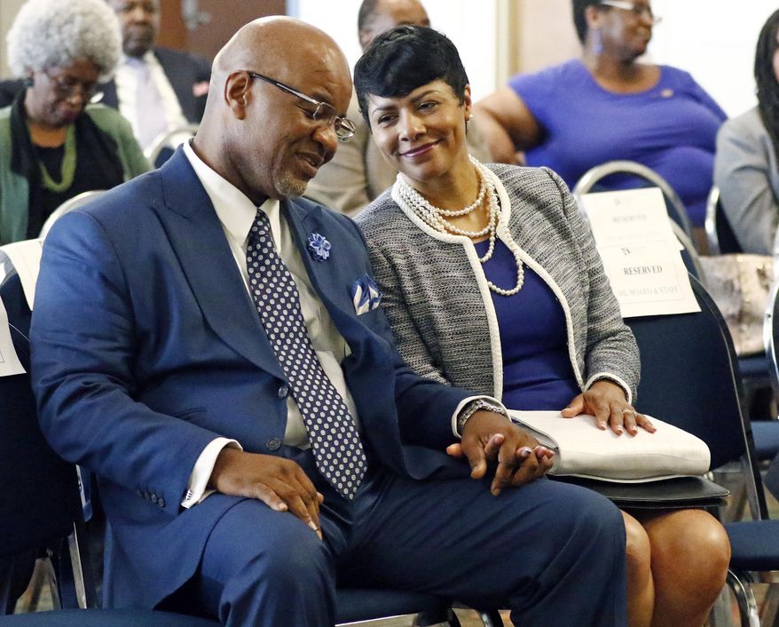 Deborah Bynum, right, wife of current Mississippi Valley State President William Bynum, hold hands as they listen to him being chosen by the college board as the next president of Jackson State University during a visit to the Jackson, Miss., based university, to meet with students, professors and members of the community and alumni, Wednesday, May 31, 2017. Bynum, was the preferred candidate of the college board. (AP Photo/Rogelio V. Solis)