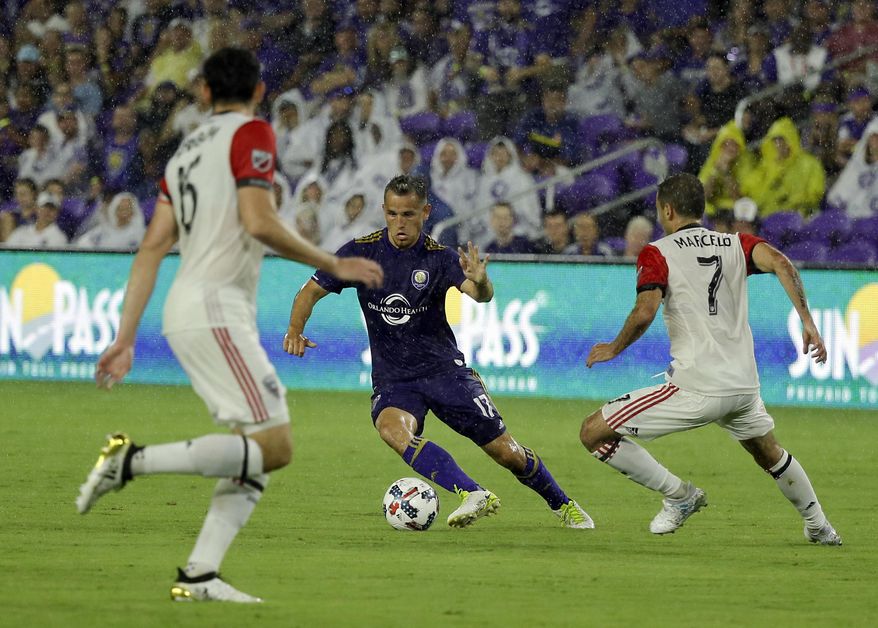 Orlando City&#39;s Luis Gil (17) moves the ball between D.C. United&#39;s Steve Birnbaum, left, and Marcelo Sarvas (7) during the first half of an MLS soccer game, Wednesday, May 31, 2017, in Orlando, Fla. (AP Photo/John Raoux)