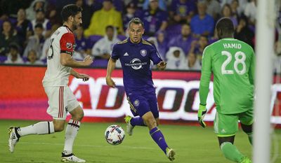 Orlando City&#39;s Luis Gil, center, attempts a shot on goal between D.C. United&#39;s Steve Birnbaum, left, and goalkeeper Bill Hamid (28) during the first half of an MLS soccer game, Wednesday, May 31, 2017, in Orlando, Fla. (AP Photo/John Raoux)