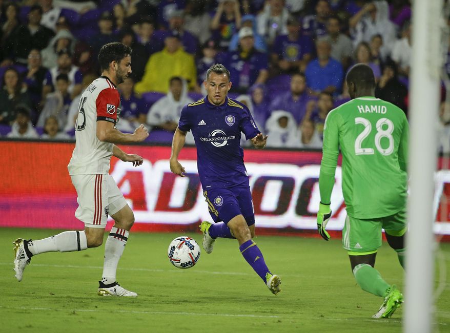 Orlando City&#39;s Luis Gil, center, attempts a shot on goal between D.C. United&#39;s Steve Birnbaum, left, and goalkeeper Bill Hamid (28) during the first half of an MLS soccer game, Wednesday, May 31, 2017, in Orlando, Fla. (AP Photo/John Raoux)