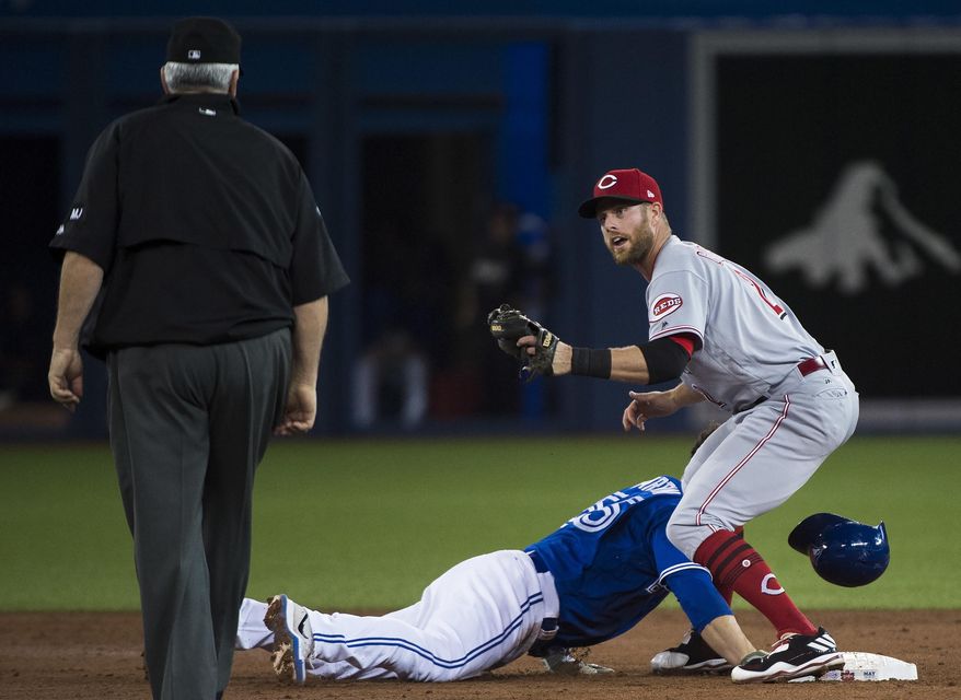 Toronto Blue Jays third baseman Russell Martin (55) is tagged out at second base by Cincinnati Reds shortstop Zack Cozart (2) after being picked off during second inning interleague baseball action in Toronto on Wednesday, May 31, 2017. (Nathan Denette/The Canadian Press via AP)