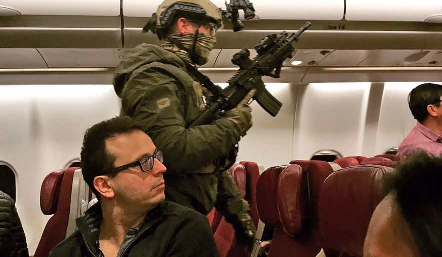 Police in tactical gear board a Malaysia Airlines plane after a man tried to enter its cockpit in Melbourne, Australia, Thursday, June 1, 2017. The Malaysia Airlines plane returned to Australia after the man threatened to detonate a bomb and attempted to enter the cockpit before he was tackled and tied up by passengers, police said Thursday. The 25-year-old Sri Lankan man had been discharged from a Melbourne psychiatric hospital on Wednesday before buying a ticket on the late-night flight to Kuala Lumpur, Malaysia. (Andrew Leconcelli via AP)