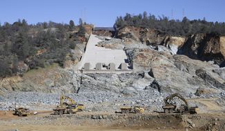 FILE - In this Feb. 28, 2017, file photo, construction crews clear rocks away from Oroville Dam&#39;s crippled spillway in Oroville, Calif. The sudden collapse of spillways at the nation&#39;s highest dam was unique because it came without warning, and the investigation into why that was is sure to change the way big dams are built and run around the world, an independent team searching for explanations into this winter&#39;s near-disaster at Oroville Dam says. (AP Photo/Rich Pedroncelli, File)