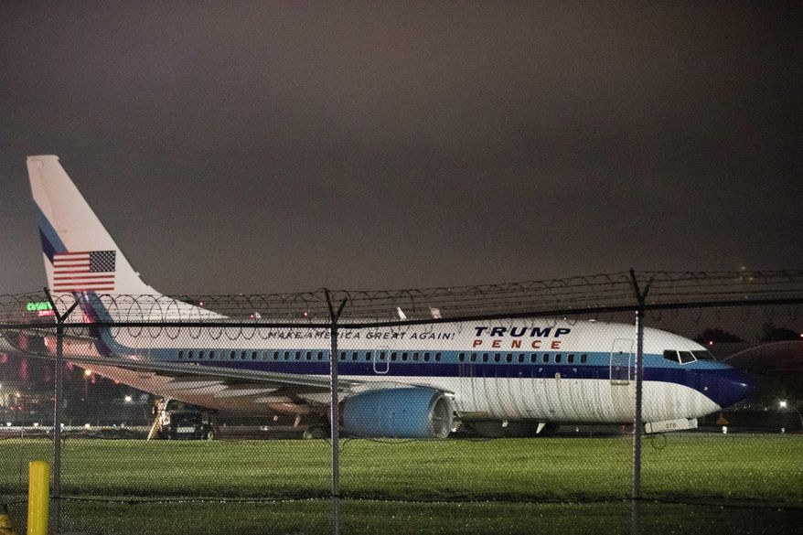 FILE- In this Oct. 27, 2016 file photo, Republican vice presidential candidate and Indiana Gov. Mike Pence's campaign airplane sits partially on the tarmac and the grass after sliding off the runway while landing at LaGuardia airport in New York. The pilots of the plane knew they were going to be in the news according to the Boeing 737's cockpit voice recording released by the National Transportation Safety Board, Wednesday, May 31, 2017. (AP Photo/Mary Altaffer, File)