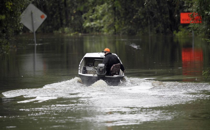 FILE - In this Oct. 5, 2015 file photo, Hunter Baker drives his boat down a flooded East Black Creek Road to his home following heavy rains in Florence, S.C. Meteorologists are now as good with their five-day forecasts as they were with their three-day forecasts in 2005. Both government and private weather forecasting companies are approaching the point where they get tomorrow’s high temperature right nearly 80 percent of the time. It was 66 percent 11 years ago, according to ForecastWatch, a private firm that rates accuracy of weather forecasts. (AP Photo/Gerry Broome)