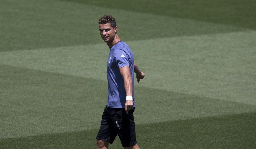 Real Madrid&#x27;s Cristiano Ronaldo stretches as he enters the field for a training session at a media open day in Madrid, Tuesday May 30, 2017. Real Madrid will play Juventus Saturday in the Champions League final in Cardiff. (AP Photo/Paul White)