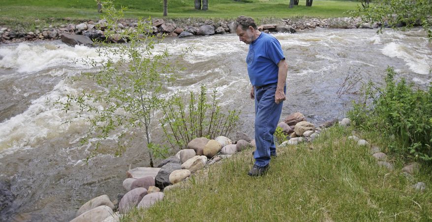In this Wednesday, May 31, 2017, photo, Ron Lenfield watches the fast-flowing Weber River along his property, in Oakley, Utah. Authorities in Utah are ratcheting up warnings telling people to stay away from the raging, icy waterways that are extremely dangerous this spring due to a snowy winter and wet spring. (AP Photo/Rick Bowmer)