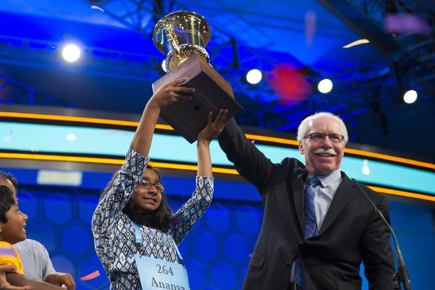 Ananya Vinay, 12, from Fresno, Calif., and Rich Boehne, president E.W. Scripps Company, hold the winners trophy aloft after she won the 90th Scripps National Spelling Bee in Oxon Hill, Md., Thursday, June 1, 2017. (AP Photo/Cliff Owen)
