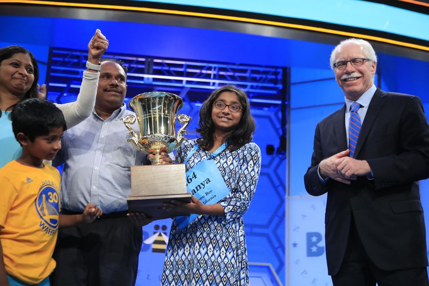 Ananya Vinay, 12, from Fresno, Calif., celebrates with her mother Anu Pama Poliyedathpp, left, and father Vinay Sreekumar, after being presented with a trophy by E.W. Scripps Company Chairman, President and Chief Executive Officer Rich Boehne, winning the 90th Scripps National Spelling Bee, right, in Oxon Hill, Md., Thursday, June 1, 2017. (AP Photo/Manuel Balce Ceneta)