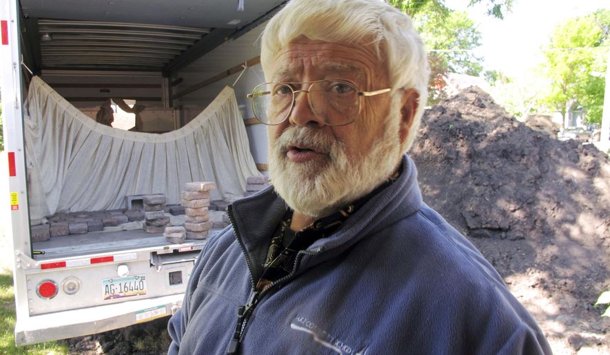 In this May 26, 2017, photo, Jim Papacek stands in the front yard of his former south Fargo, N.D., while taking a break from loading bricks onto a rented truck. Papacek lived in the house near the Red River for nearly half a century and had planned to die there, but decided he could no longer fight both the river and city officials who wanted him off the flood plain. Last fall he accepted a buyout for the home. (AP Photo/Dave Kolpack)