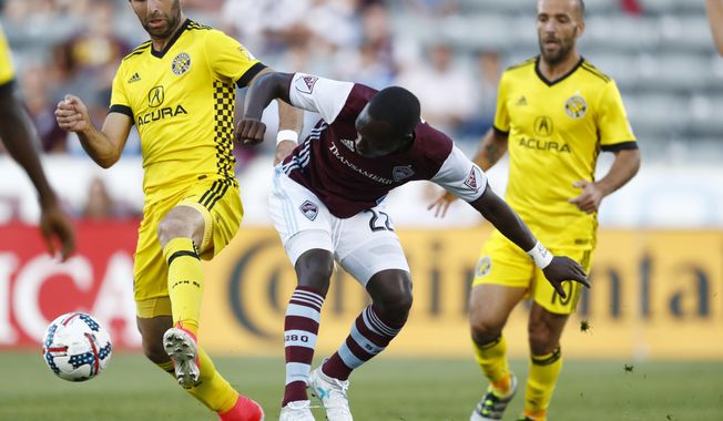Columbus Crew forward Justin Meram, left, fights for control of the ball with Colorado Rapids midfielder Michael Azira, center, as Crew forward Federico Higuain covers in the first half of an MLS soccer game Saturday, June 3, 2017, in Commerce City, Colo. (AP Photo/David Zalubowski)
